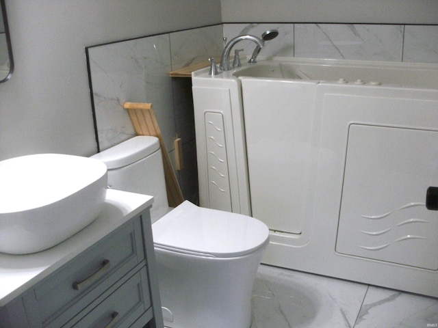 bathroom featuring vanity, a bath, and toilet