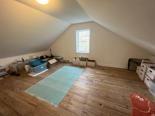 additional living space with wood-type flooring and lofted ceiling