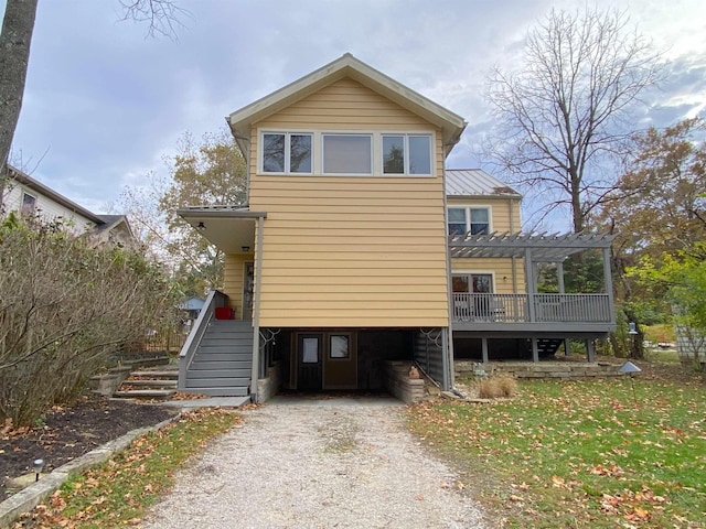 view of front of home featuring a front yard, a deck, and a pergola