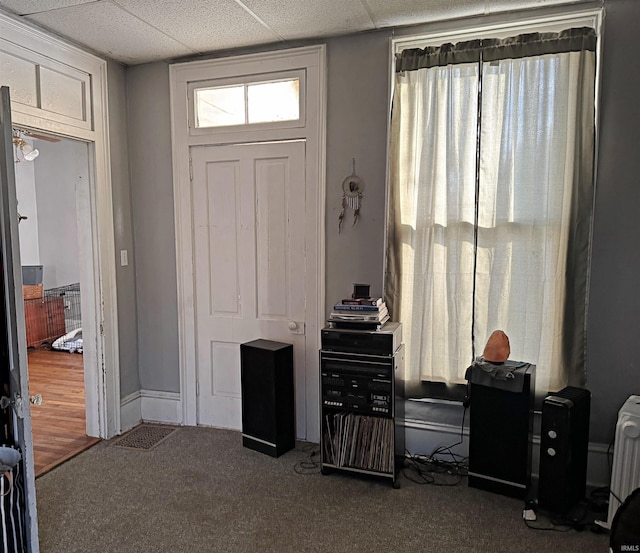 interior space featuring radiator and a drop ceiling