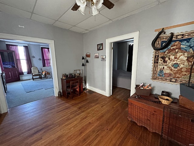 hallway featuring dark wood-type flooring and a paneled ceiling