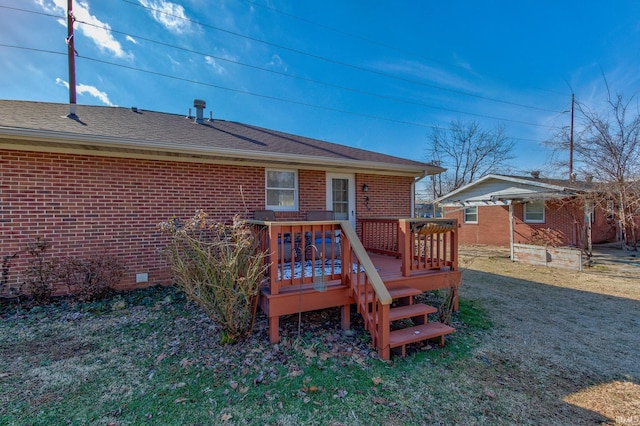 rear view of property with a yard and a deck