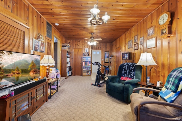 living room with ceiling fan with notable chandelier, light colored carpet, wooden ceiling, and wooden walls