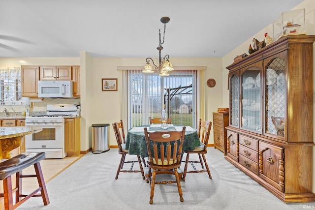 dining area with light carpet and a notable chandelier