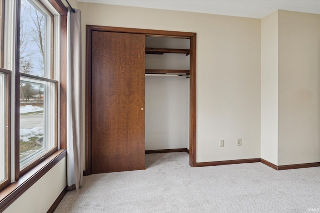 unfurnished bedroom featuring light colored carpet and a closet