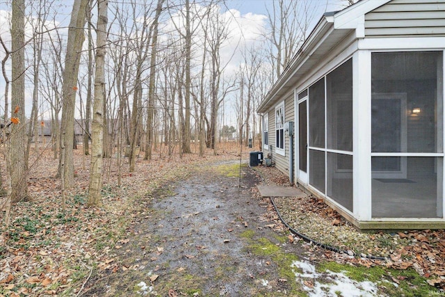 view of yard with central AC and a sunroom