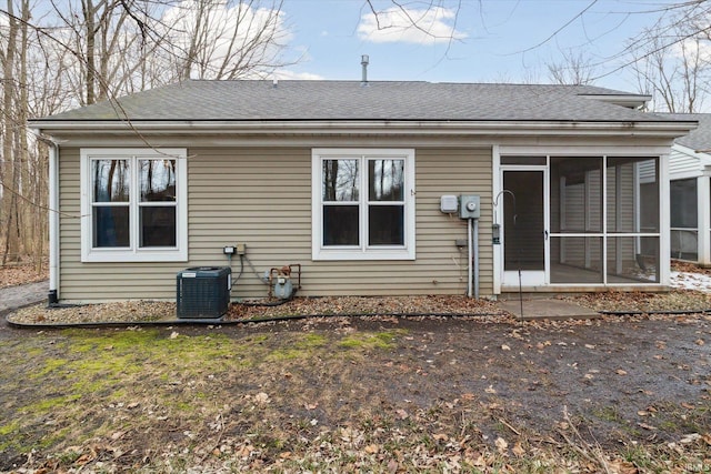 rear view of house with cooling unit and a sunroom