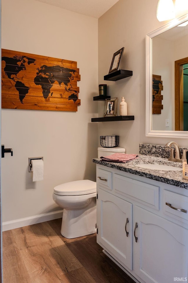 bathroom featuring wood-type flooring, vanity, and toilet