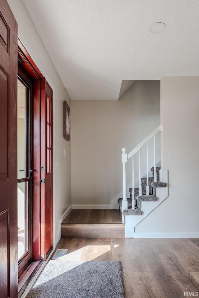 stairway with hardwood / wood-style floors