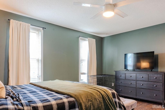 bedroom featuring ceiling fan, hardwood / wood-style floors, and a textured ceiling