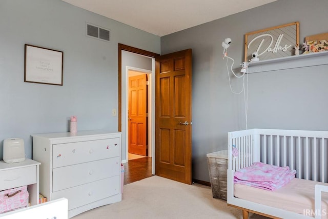 carpeted bedroom featuring a crib