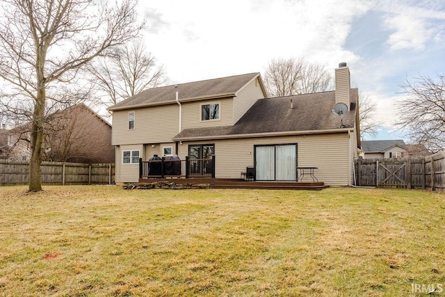 rear view of property with a wooden deck and a yard