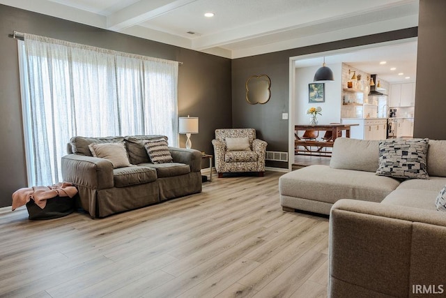 living room with beam ceiling and light hardwood / wood-style floors