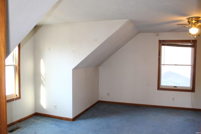 additional living space featuring lofted ceiling, a healthy amount of sunlight, light carpet, and ceiling fan