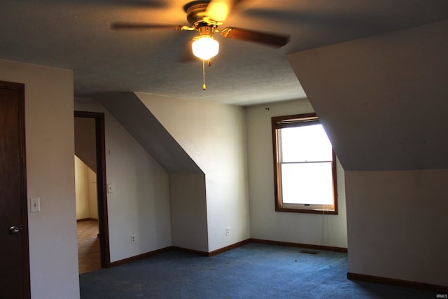 bonus room featuring ceiling fan and dark colored carpet