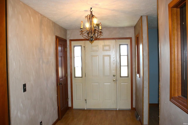 entrance foyer with an inviting chandelier and light hardwood / wood-style flooring