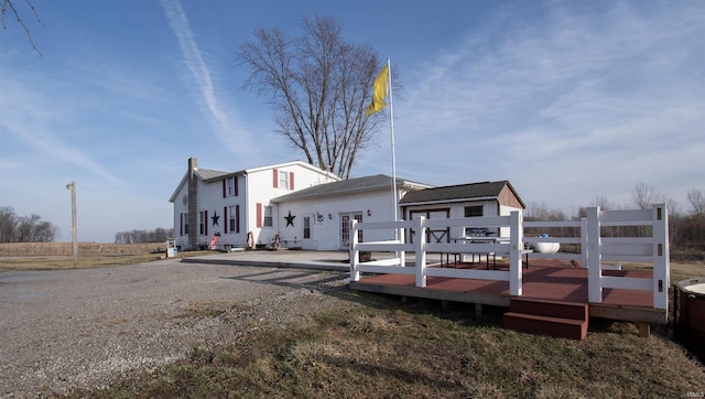 back of property featuring a wooden deck and an outbuilding