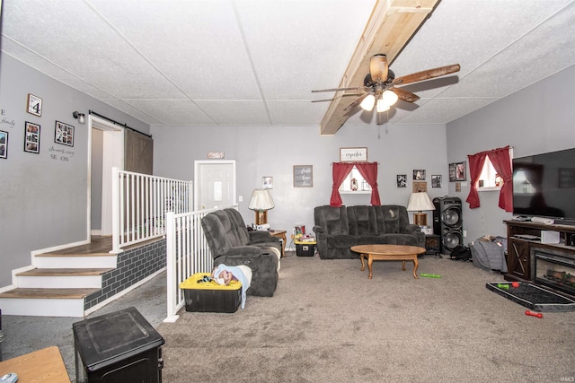 living room featuring carpet floors, a barn door, ceiling fan, and a paneled ceiling