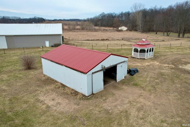 exterior space featuring a rural view, a yard, and an outdoor structure