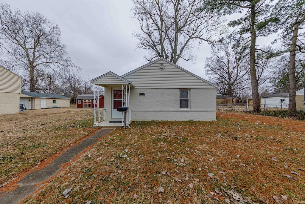 view of front of house featuring a front yard and a storage unit