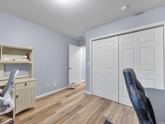 office space with light hardwood / wood-style floors and a textured ceiling