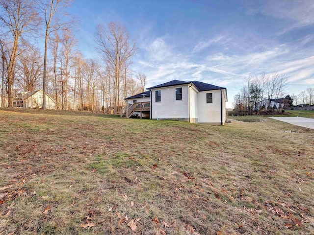 view of property exterior featuring a yard and a deck