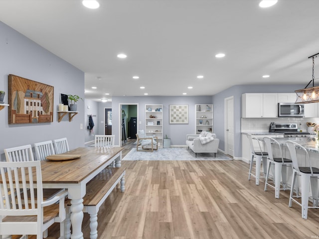 dining space featuring built in shelves and light hardwood / wood-style floors