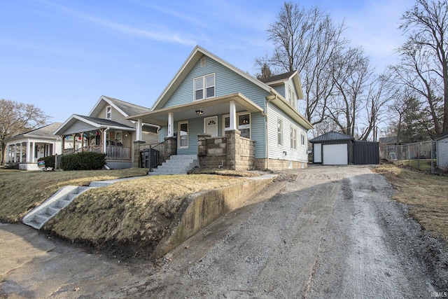 view of front facade with a garage, an outdoor structure, and a porch