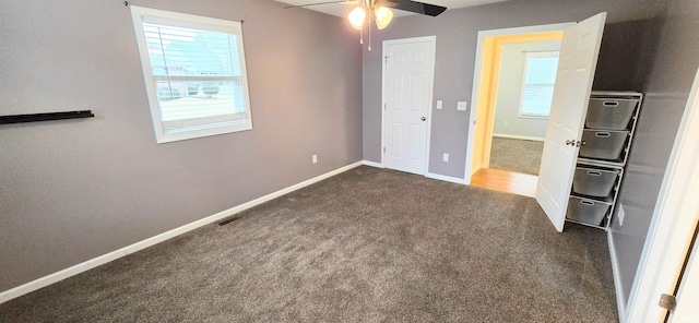 unfurnished bedroom featuring ceiling fan and dark carpet