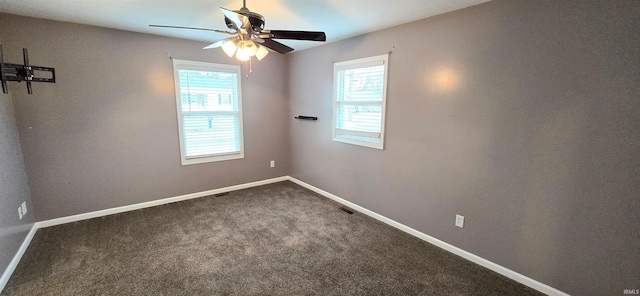 empty room with carpet floors, a wealth of natural light, and ceiling fan