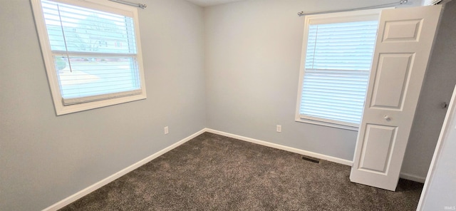 empty room featuring dark colored carpet