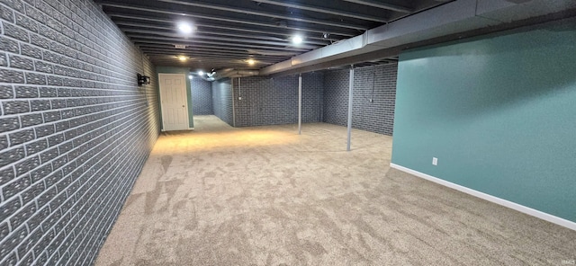 basement featuring brick wall and carpet floors