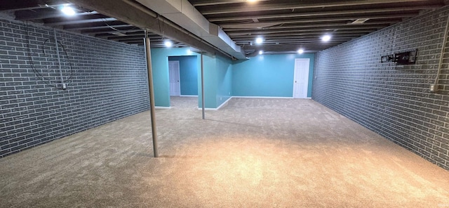 basement with brick wall and light colored carpet