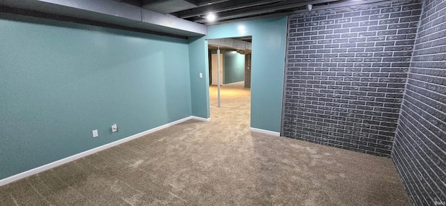 basement featuring carpet floors and brick wall