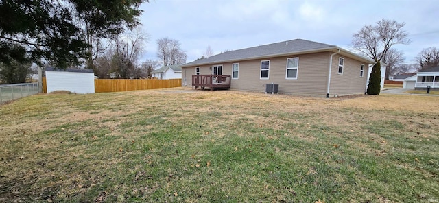 back of house featuring a deck, a lawn, central air condition unit, and a storage unit