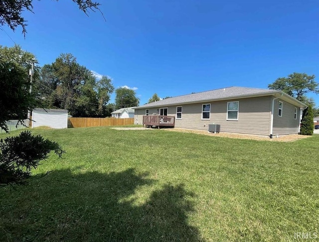 rear view of property featuring a wooden deck, a yard, and central AC