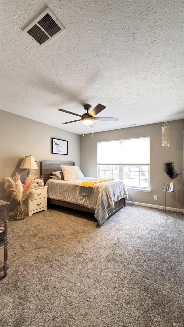 carpeted bedroom with ceiling fan and a textured ceiling