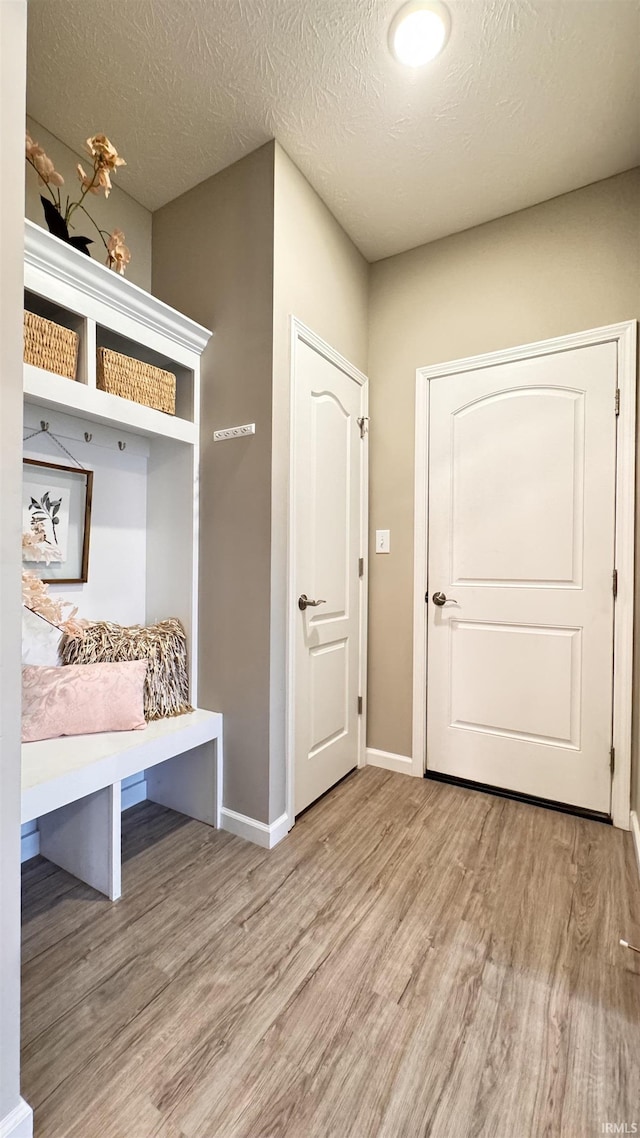 mudroom with a textured ceiling and light hardwood / wood-style floors