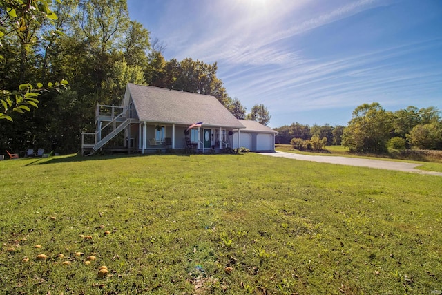 cape cod home with a garage, covered porch, and a front lawn