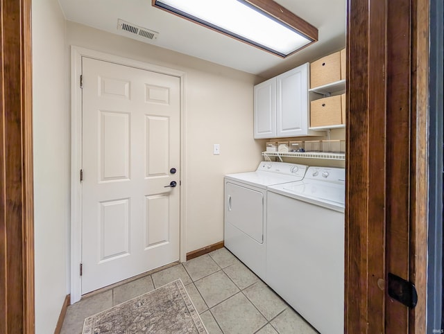 laundry room with cabinets, washer and dryer, and light tile patterned floors