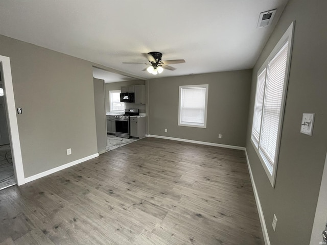 unfurnished living room featuring ceiling fan and light hardwood / wood-style floors