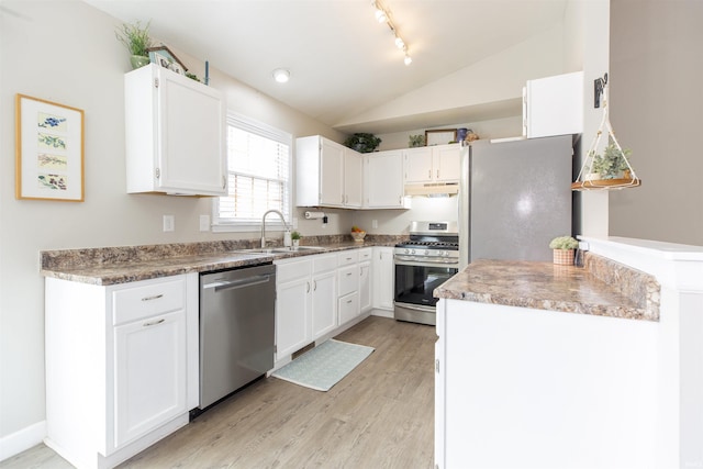 kitchen with lofted ceiling, sink, appliances with stainless steel finishes, light hardwood / wood-style floors, and white cabinets