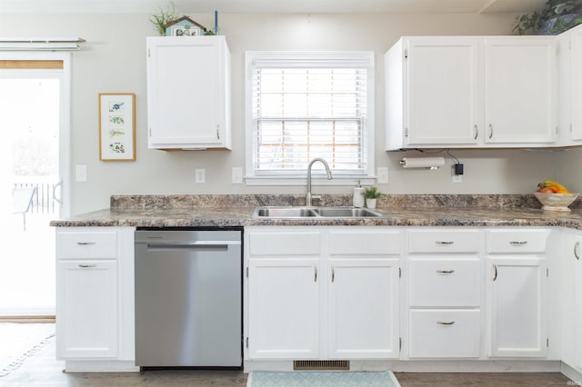 kitchen featuring sink, white cabinets, dishwasher, and light wood-type flooring