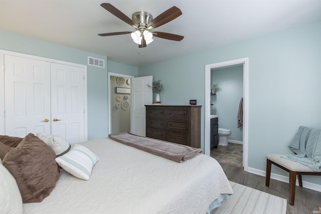 bedroom with ceiling fan, dark hardwood / wood-style floors, ensuite bath, and a closet