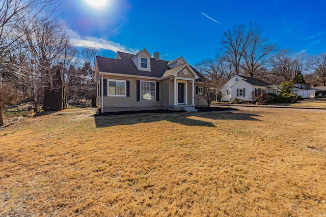 cape cod home featuring a front lawn