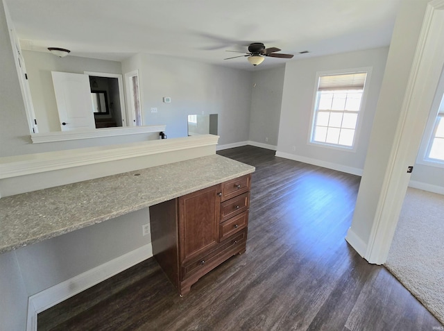 interior space with ceiling fan, dark hardwood / wood-style floors, and built in desk