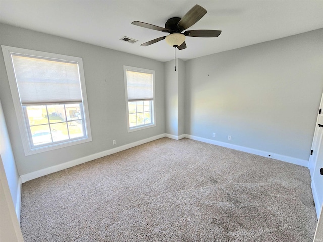 carpeted spare room featuring ceiling fan