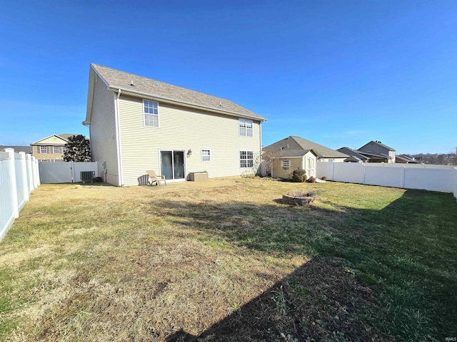 back of property featuring a lawn and central air condition unit