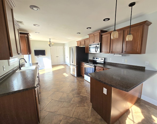 kitchen featuring sink, a breakfast bar area, stainless steel appliances, decorative light fixtures, and kitchen peninsula