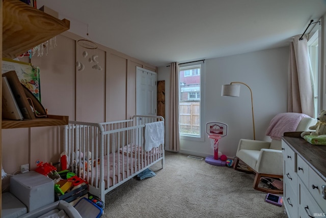 bedroom with light colored carpet and a crib